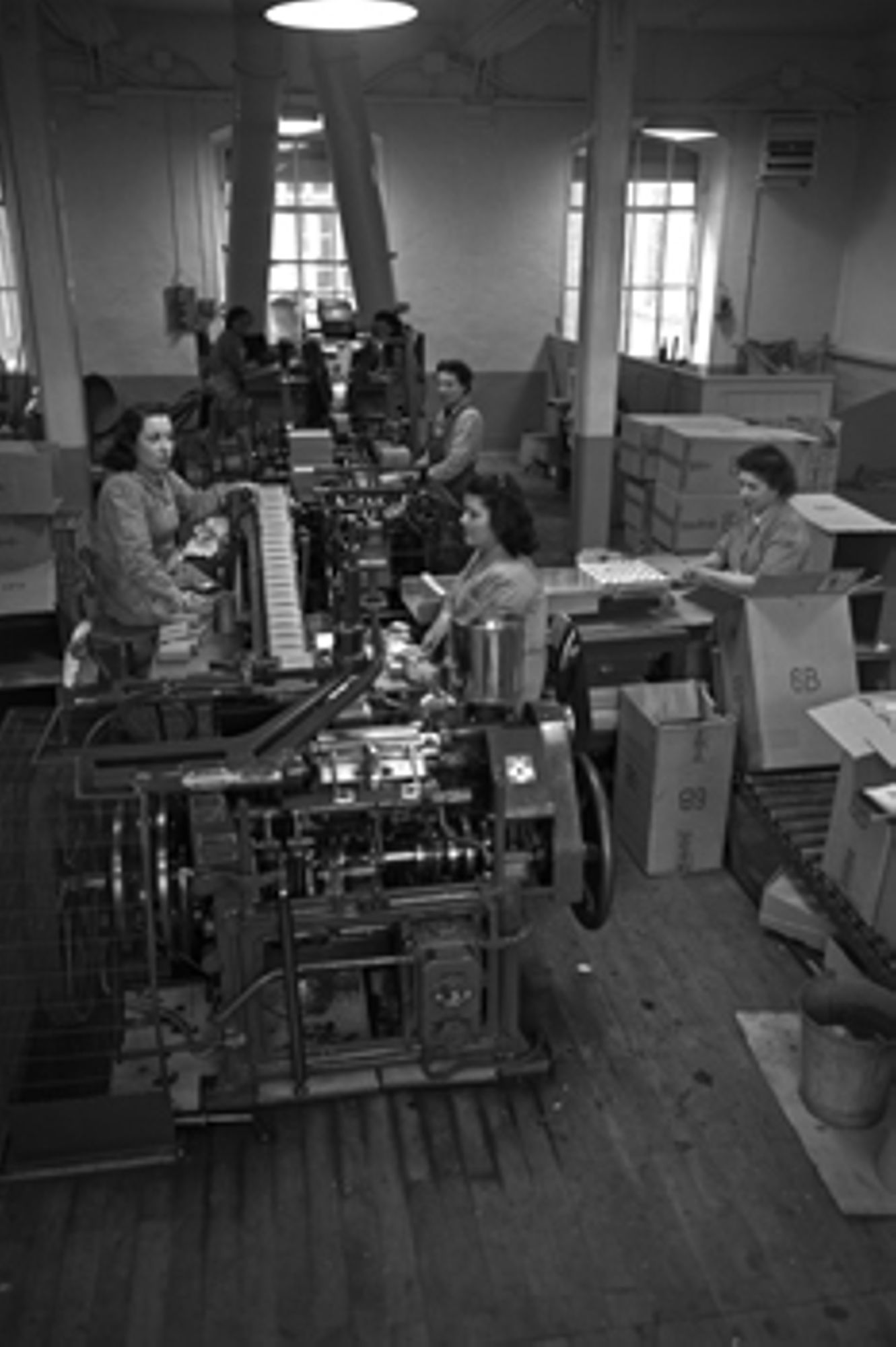 Ouvrière de la manufacture des tabacs d’Orléans devant la machine à empaqueter le tabac scaferlati [1945-1960].